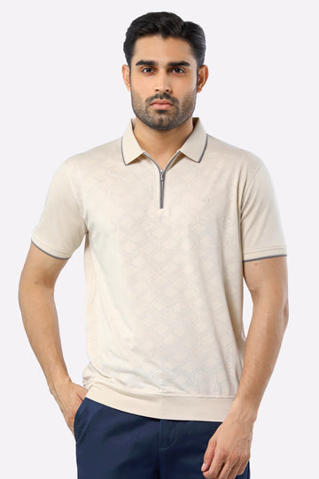 Man wearing a beige short-sleeve polo shirt with a zipper on a white background